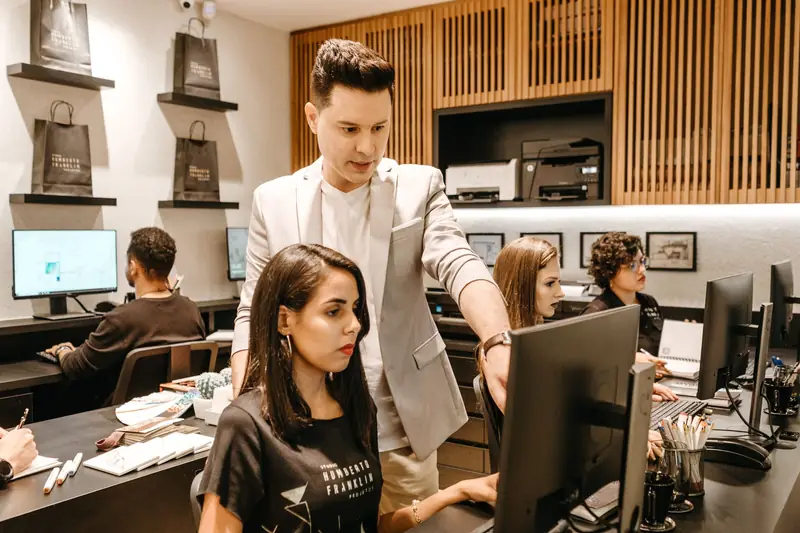 IT-medewerker helpt een collega aan haar computer