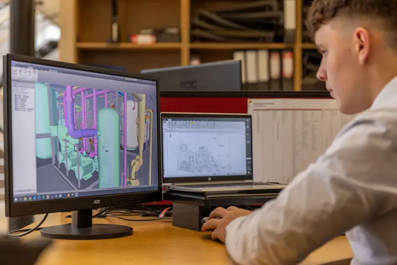 Ingenieur werkt aan een 3D CAD-model van een technische installatie op een groot beeldscherm